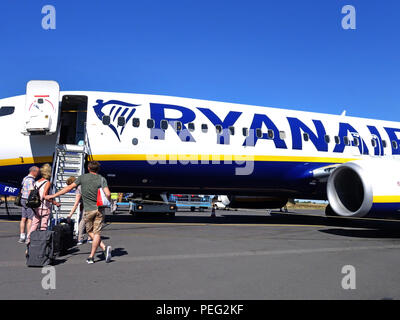 Passeggeri a piedi attraverso la tarmac verso loro homeward volo su un aereo Ryanair Foto Stock