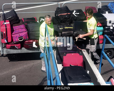 Il bagaglio di essere messo su un nastro trasportatore in un piano a Beziers Cap d Agde aeroporto, Francia, mostra due bagagli a lavorare Foto Stock