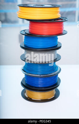 ABS e PLA filament accanto alla stampante 3D. Bobine di plastica Foto Stock