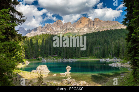 Lago di Carezza Lago di Carezza () e la foresta di conifere. Sullo sfondo il gruppo del Catinaccio gruppo. Le Dolomiti del Trentino Alto Adige. Alpi italiane, l'Europa. Foto Stock