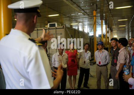 150818-M-GO800-008 Da Nang, Vietnam (18 agosto 2015) - Tenente j.g. Mark Roach spiega a locale i funzionari vietnamiti la funzione della Mission Bay a bordo i militari Sealift giunto di comando alta velocità nave USNS Millinocket JHSV (3) durante un tour della nave il Agosto 18. Task Force Forager, imbarcato a bordo del Millinocket serve come piattaforma secondaria per Pacific Partnership, guidato da un comando expeditionary elemento dalla Marina militare del 30 Costruzione navale Regiment (30 NCR) da Port Hueneme, California Ora nella sua decima iterazione, Pacific Partnership è il più grande annuale multilaterale assis umanitario Foto Stock