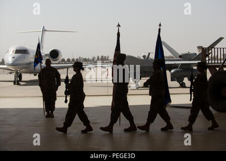 Stati Uniti Avieri con il Kandahar Airfield Guardia d'onore marzo con i colori durante l'aria 451st Expeditionary Modifica Gruppo del comando cerimonia presso Kandahar Airfield, Afghanistan, Agosto 16, 2015. Durante la cerimonia Col. Rhude Cherry III rinunciato il comando della AEG 451st al Col. James Curry. (U.S. Air Force foto di Tech. Sgt. Giuseppe Swafford/rilasciato) Foto Stock