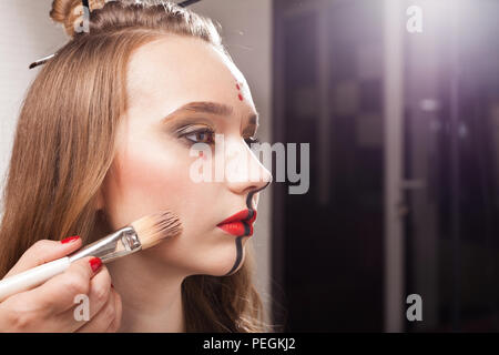 Make up donna applicando foundation su un modello Foto Stock