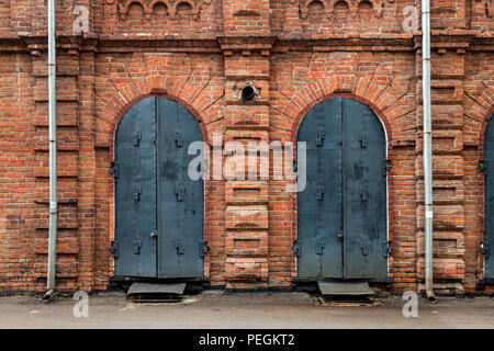 Close-up di un metallo porta nera nella vecchia casa di un palazzo fatto di mattoni vecchi Foto Stock