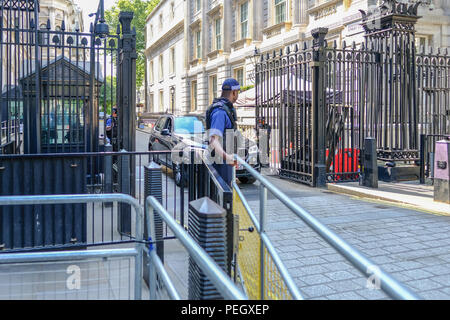 A Downing Street, London, Regno Unito - 8 Giugno 2018: polizia armata proteggere l'acciaio nero ingresso sincronizzato a Downing Street. Mostra un auto viene lasciata fuori. Foto Stock