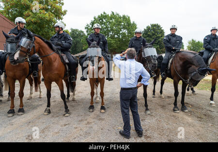 Willich, Germania. Il 15 agosto, 2018. Herbert Reul (CDU), il ministro degli Interni dello stato della Renania settentrionale-Vestfalia, è in piedi di fronte a poliziotti montati durante una visita per il NRW squadra di equitazione. Il ministro è informato circa il lavoro, operazioni e addestramento di piloti di polizia. Credito: Christophe Gateau/dpa/Alamy Live News Foto Stock