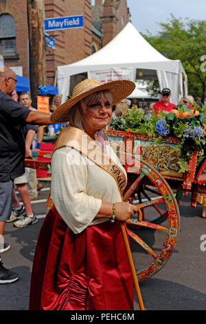 Cleveland, Ohio, USA. Il 15 agosto, 2018. Una Donna vestita di patrimonio italiano outfit sorge su Mayfield Road al di fuori della santa Chiesa del Rosario in attesa per il centoventesimo festa dell Assunta processione per iniziare. Credito: Mark Kanning/Alamy Live News Foto Stock