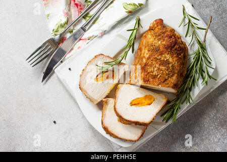 Rotolo di carne (involtino) con ripieno di albicocca e spezie su una luce di pietra o di sfondo di ardesia. La Giornata del ringraziamento antipasto. Vista superiore piatta backgrou laici Foto Stock