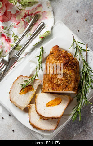 Rotolo di carne (involtino) con ripieno di albicocca e spezie su una luce di pietra o di sfondo di ardesia. La Giornata del ringraziamento antipasto. Vista superiore piatta backgrou laici Foto Stock