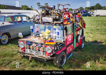 Un esilarante presentano a countgry vintage FAIR in Inghilterra WILTSHIRE REGNO UNITO con un vecchio kit car adornata con una miriade di giocattoli per bambini e ephemera Foto Stock