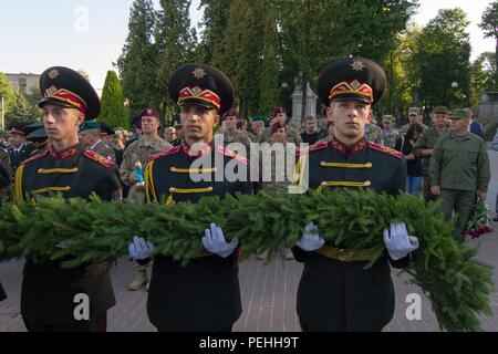 Soldati con forze armate ucraine portano una ghirlanda di cerimoniale presso un'indipendenza ucraina giorno osservanza 24 agosto 2015, in Leopoli, Ucraina, onorando gli ucraini uccisi durante lo scorso anno la rivoluzione in Kiev. I paracadutisti con gli Stati Uniti Dell'esercito 173rd Brigata Aerea ha partecipato alla cerimonia per sostenere i loro partner ucraini nella loro celebrazione di indipendenza e di rispetto per le persone che hanno sacrificato la loro vita per l'indipendenza dell'Ucraina. I paracadutisti sono in Ucraina per la seconda delle diverse rotazioni pianificate per il treno dell'Ucraina neo-costituita la guardia nazionale come parte di intrepidi Guardi Foto Stock