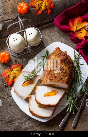 Rotolo di carne (involtino) con ripieno di albicocca e spezie in cucina un tavolo di legno. La Giornata del ringraziamento antipasto. Foto Stock