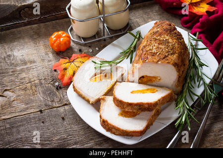 Rotolo di carne (involtino) con ripieno di albicocca e spezie in cucina un tavolo di legno. La Giornata del ringraziamento antipasto. Copia dello spazio. Foto Stock