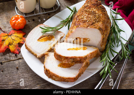 Rotolo di carne (involtino) con ripieno di albicocca e spezie in cucina un tavolo di legno. La Giornata del ringraziamento antipasto. Foto Stock