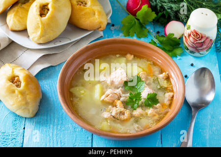 Zuppa di salmone (orecchie) e aprire torte con pesce rosso sulla cucina sullo sfondo di legno. Cucina russa. Copia dello spazio. Foto Stock