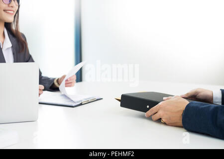 Donna Manager condurre un colloquio di lavoro con il richiedente femmina guardando lei quizzically con il suo CV in mano e a parlare con il suo subordinato a h Foto Stock