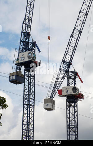 Una coppia di gru a torre su un sito di costruzione. Due gru a torre. Concetto di edilizia, sviluppo, lavori di costruzione Foto Stock