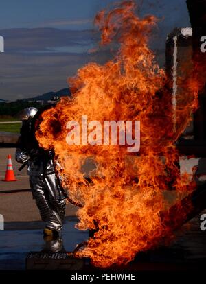 Il personale Sgt. Michael bianco, 51st ingegnere civile Squadron capo equipaggio, sorge alle spalle di un aeromobile a fuoco durante un evento di formazione Aug 26, 2015, a Osan Air Base, Repubblica di Corea. Le aree esterne della pratica degli aeromobili sono accese fino al test come i vigili del fuoco di gestire lo spegnimento di incendi al di fuori della simulazione di crash aereo, quindi all'interno del cockpit dove sono i piloti e infine, all'interno del vano di carico per cercare di salvare o recuperare qualsiasi attrezzatura. (Brevetto statunitense n. S. Air Force photo by Staff Sgt. Benjamin Sutton) Foto Stock