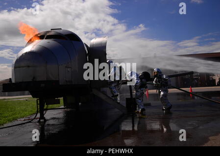 Due vigili del fuoco dalla Songtan fire station seguite dal personale Sgt. Michael bianco, 51st ingegnere civile Squadron capo equipaggio, immettere un aeromobile di addestramento per eseguire un estinguente esercitare il Agosto 26, 2015, a Osan Air Base, Repubblica di Corea. I vigili del fuoco dalla 51st CES ha recentemente ospitato un incendio-evento di formazione e ha invitato i vigili del fuoco locali nonché i vigili del fuoco dalla Repubblica di Corea Air force a partecipare. (Brevetto statunitense n. S. Air Force photo by Staff Sgt. Benjamin Sutton) Foto Stock