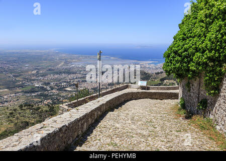 Erice in Sicilia, vista dalla strada intorno al Castello di Venere verso il mare e la città di Trapani. Isola di Favignana è visibile sull'orizzonte Foto Stock