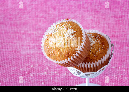 Fatti in casa muffin alla vaniglia con polvere di noce di cocco. Sfondo rosa. Copia dello spazio. Fcus selettiva. Foto Stock