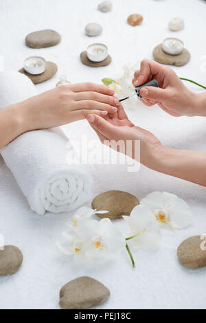 Facendo una favolosa french manicure. Salon lavoratore l'applicazione di rivestimento di base sul client le unghie. Foto Stock