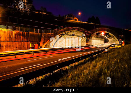 Una lunga esposizione colpo di un autostrada vicino a Friburgo in Svizzera con veicoli e camion di entrare in galleria Foto Stock