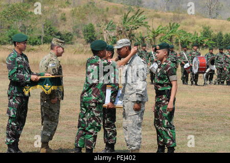 Il Mag. Gen. Agus Suhardi, capo del personale, 1° Kostrad divisione di fanteria, Tentara Nasional Indonesia Angkatan Darat (TNI-AD) rimuove un scudo di Garuda cordino da collo di un soldato assegnati al 2° Battaglione, 27° Reggimento di Fanteria, 3° Brigata Team di combattimento, XXV divisione di fanteria, durante la cerimonia di chiusura della protezione Garuda 2015 in Cibenda, Indonesia, Agosto 28, 2015. Foto Stock