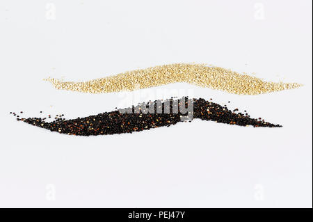 Grani di bianco e nero di quinoa isolati su sfondo bianco. Foto Stock