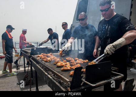 Golfo di Aden (Agosto29, 2015) marinai pollo barbecue durante un acciaio picnic sulla spiaggia sul ponte di volo del San Antonio-classe di trasporto anfibio dock nave USS ancoraggio (23 LPD). Ancoraggio è parte dell'Essex anfibio gruppo pronto (ARG) e, con avviato xv Marine Expeditionary Unit (MEU), è distribuito come supporto di le operazioni di sicurezza marittima e di teatro la cooperazione in materia di sicurezza gli sforzi negli Stati Uniti Quinta Flotta area di operazioni. (U.S. Foto di Marina di Massa Communications Specialist 2a classe Matthew Dickinson/rilasciato) Foto Stock