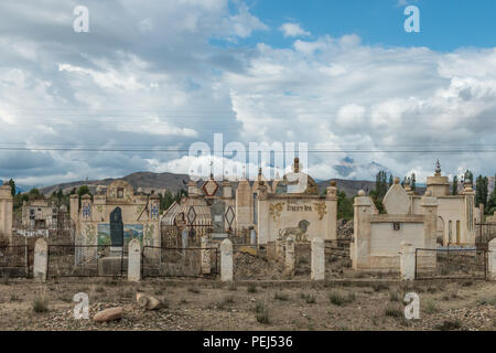 Il vecchio era Sovietica cimitero con formazione di ruggine tombe nel deserto alpino vicino Bokonbayevo, Kirghizistan Foto Stock