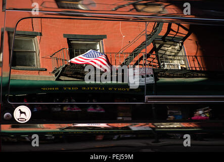 I riflessi della bandiera americana nel lato di un pannello nero van, Little Italy, New York, Stati Uniti d'America Foto Stock