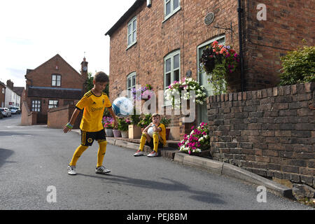 I ragazzi in Wolverhampton Wanderers FC kit replica a giocare a calcio al di fuori del luogo di nascita di lupi e Inghilterra leggenda calcistica di Billy Wright in Ironb Foto Stock