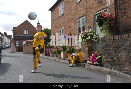 I ragazzi in Wolverhampton Wanderers FC kit replica a giocare a calcio al di fuori del luogo di nascita di lupi e Inghilterra leggenda calcistica di Billy Wright in Ironb Foto Stock