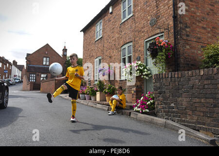 I ragazzi in Wolverhampton Wanderers FC kit replica a giocare a calcio al di fuori del luogo di nascita di lupi e Inghilterra leggenda calcistica di Billy Wright in Ironb Foto Stock