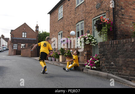 I ragazzi in Wolverhampton Wanderers FC kit replica a giocare a calcio al di fuori del luogo di nascita di lupi e Inghilterra leggenda calcistica di Billy Wright in Ironb Foto Stock