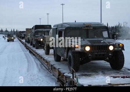 Humvees e altri veicoli di aspettare di essere guidato fuori le vetture del treno a Fort Wainwright, Alaska il 9 dicembre 2015. Il ritorno dei veicoli segnala la fine del Pacifico Pathways missione in Giappone e Corea. Foto Stock