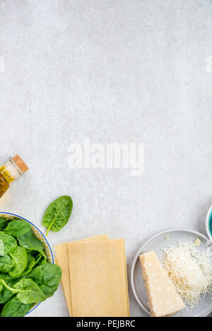 Ingredienti per vegetariani di spinaci e ricotta lasagne, vista dall'alto e sfondo grigio Foto Stock