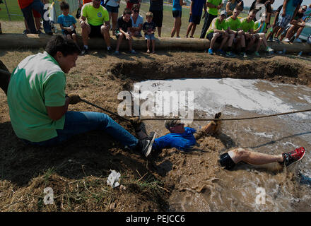 I membri del novantesimo forza squadrone di supporto slitta nel pozzo del fango come perdono il campionato Tug-of-War corrisponde il Agosto 21, 2015, durante l'annuale festa Frontiercade su F.E. Warren Air Force Base, Wyo. Ogni anno, avieri del novantesimo Missile parafango e le loro famiglie si riuniscono per competere in tali eventi come ferri di cavallo, pallavolo e un bufalo-chip mescolare. (U.S. Air Force foto di R.J. Oriez/rilasciato) Foto Stock