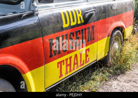Thale, Sassonia-Anhalt, Germania, luglio 12, 2018: Old Dirty brutto Trabant con nero-rosso-oro dipingere come pubblicità per il GDR Museum Thale, primo piano. Foto Stock