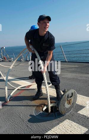 150831-N-AX546-251 MAR NERO (Agosto 31, 2015) Deck marinaio Anthony Cooke-Dixon, nativo di Portland, Oregon, heaves una linea di ormeggio da una griglia a bordo della USS Donald Cook (DDG 75) in preparazione per un evoluzione di ormeggio in Odessa, Ucraina. Donald Cook, un Arleigh Burke-class guidato-missile distruttore, sta conducendo operazioni navali negli Stati Uniti Sesta flotta area di operazioni a sostegno degli Stati Uniti per gli interessi di sicurezza nazionali in Europa. (U.S. Foto di Marina di Massa lo specialista di comunicazione 1a classe Sean Spratt /rilasciato) Foto Stock