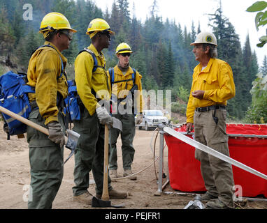 Spc. Ashley Thorton, centro sinistra, nativo di Savannah, Ga. e i suoi compagni soldati, tutti assegnati alla Task Force Primo Round, al di fuori della base comune Lewis-Mccorda, parlare di Ray Miller, Onata Fire Safety Officer in tra il conduttore di soppressione incendi operazioni in Colville National Forest, Washington, il Agosto 29. 2015. Miller ha parlato ai soldati circa il corretto le vie di fuga e come essere sempre prestando attenzione a causa di un incendio possono modificare in un istante. Foto Stock