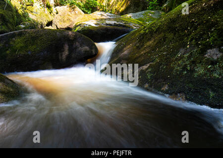 Esposizione lunga cascata nella foresta di Huelgoat, Bretagne, Francia. Foto Stock