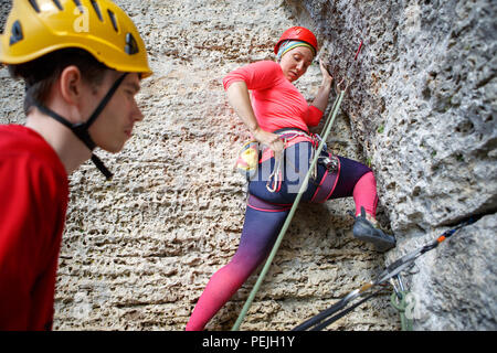 Foto di donna arrampicata su roccia e istruttore maschio Foto Stock