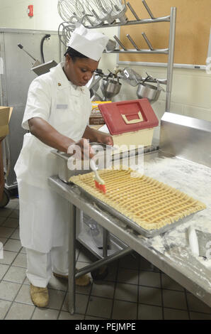 Spc. Tabatha Buckley, food service specialist con 3d reggimento di cavalleria, spazzole burro sul suo calzolaio apple pie prima di metterla in forno a Theodore Roosevelt Ristoranti Impianto di Fort Hood in Texas, nov. 24. Buckley cotta per un totale di cinque apple calzolai per la DFAC il Giorno del Ringraziamento il pranzo. (Foto di Staff Sgt, Tomora Clark 3d Cav. Regt. Affari pubblici NCOIC) Foto Stock