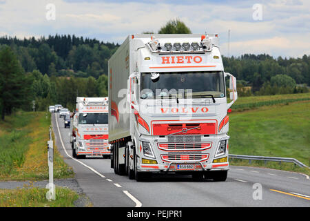 IKAALINEN, Finlandia - 12 agosto 2018: due coloratissimi Volvo FH carrelli di trasporto merci di Jarmo Hieto Oy sulla strada di ritorno dal carrello di alimentazione mostra 2018. Foto Stock