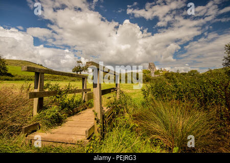 Ponte di legno attraverso Corfe Fiume con vista sulla campagna verso Corfe Castle vicino a Wareham Dorset, Regno Unito Foto Stock