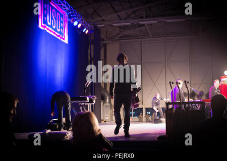 Song writer Brett James esce dalla fase dopo aver eseguito in un uso mostra per i militari e le loro famiglie a Ramstein Air Base, Germania, Dicembre 9, 2015. L'uso di animatori ha viaggiato in diverse ubicazioni per visitare i membri del servizio che vengono distribuiti da casa durante le vacanze. (DoD foto di D. Myles Cullen/rilasciato) Foto Stock