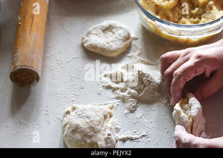 La formazione di una torta con patate da le mani delle donne close up Foto Stock