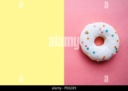Ciambella su un brillante sfondo colorato in stile minimale. Nei dintorni di posto per il testo. Foto Stock
